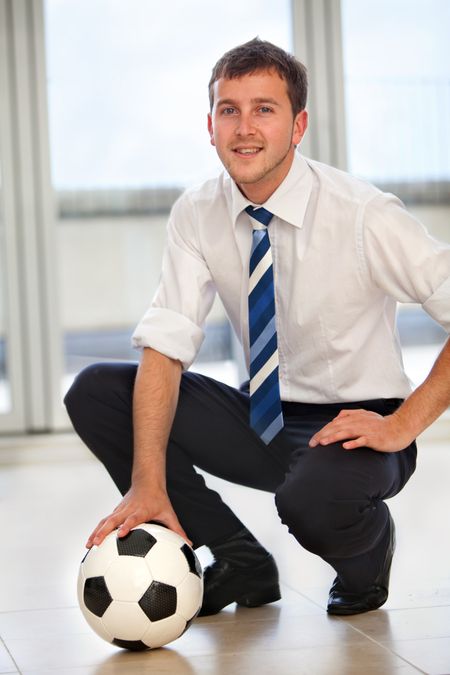 Elegant business man with a football smiling