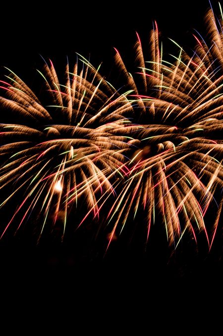 Similar bursts of fireworks with motion-blurred, feathery streaks