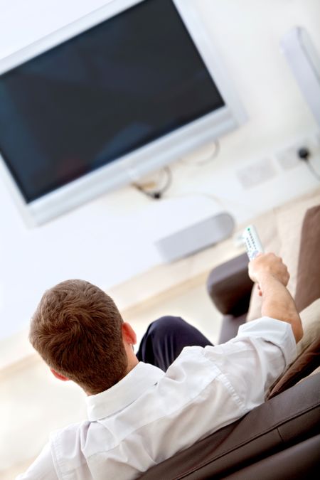 Man sitting on a couch watching television