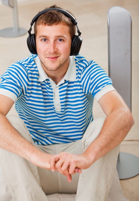 Casual man with big earphones smiling indoors