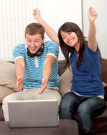 Happy couple at home watching something on the computer