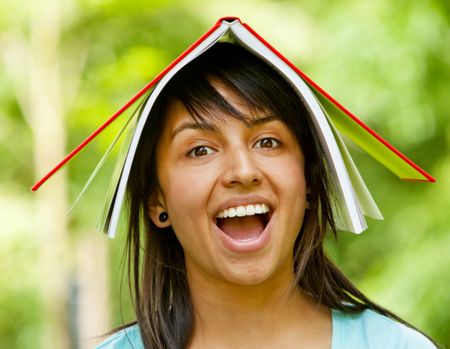girl with a notebook on her head outdoors