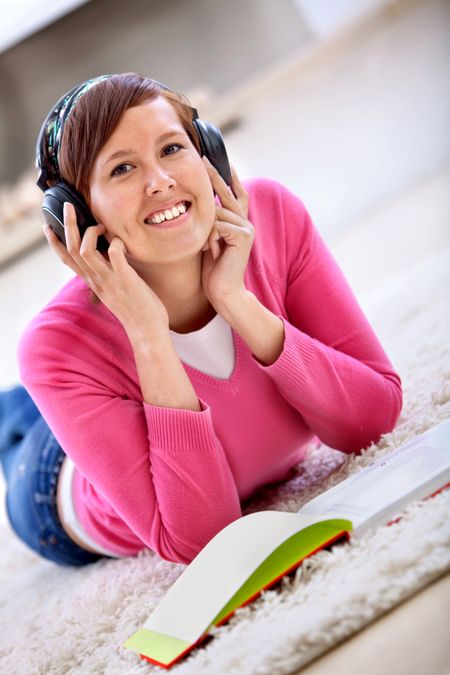 Female student with headphones and a book listening to music