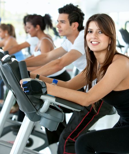 Group of gym people exercising on cardio machines