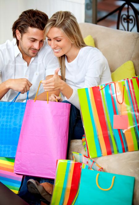 Loving couple with shopping bags at home