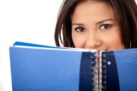 Young woman covering her face with a notebook isolated