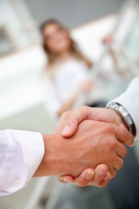 Couple of business people handshaking in an office