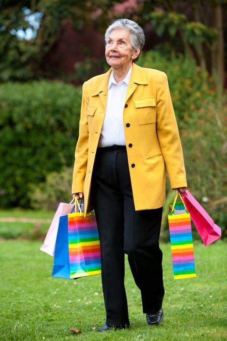 Senior woman walking outdoors with shopping bags