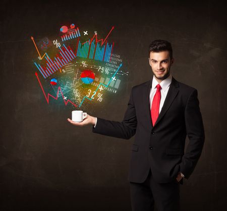 Businessman standing and holding a white cup with diagrams and graphs coming out of the cup