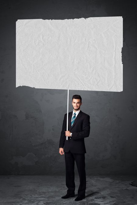 Young businessman holding a big blank booklet paper 