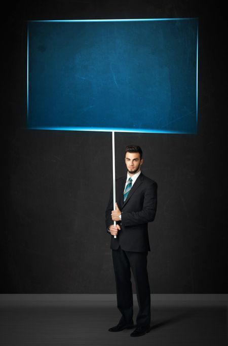 Young businessman holding a big, blue board