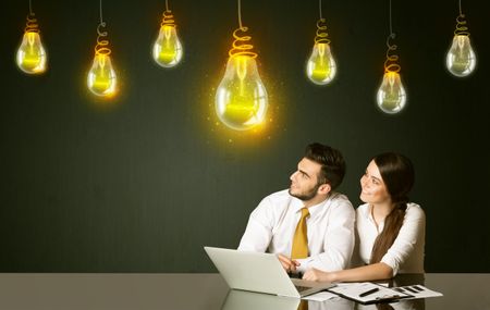Business couple sitting at the black table with idea bulbs on the background