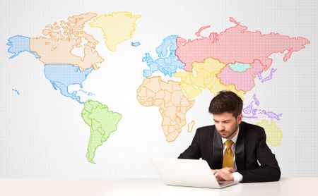 Businessman sitting at white table with colorful world map background