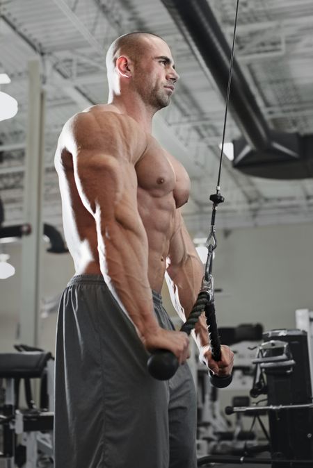 bodybuilder working out at the gym while using fitness machine
