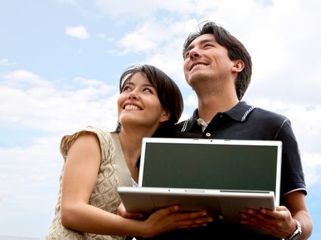 Couple of people with laptop outdoors