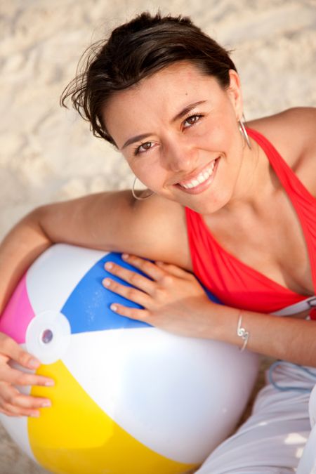Beautiful woman with a beach ball smiling