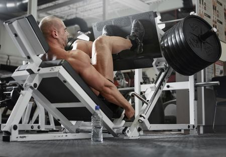 bodybuilder working out at the gym while using fitness machine