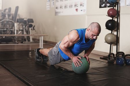 bodybuilder working out and doing push upsat the gym while