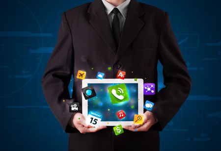 Young businessman holding a tablet with modern colorful apps and icons