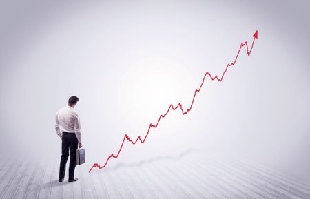 Elegant business person standing with his back looking at growing graph chart in space concept