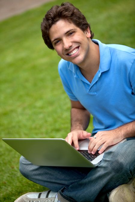 Happy man working outdoors with a laptop