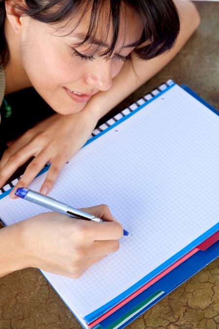 Woman studying and writing on a notebook