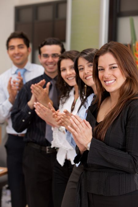 Business group portrait applauding and smiling indoors