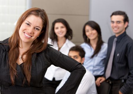 Business woman smiling with her team in an office