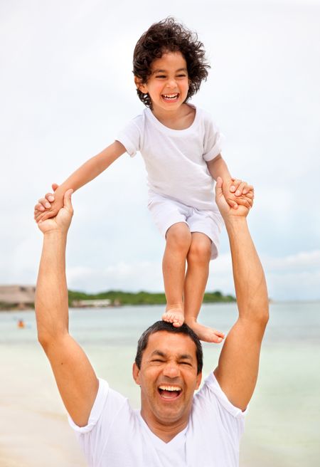 Happy father and son at the beach having fun