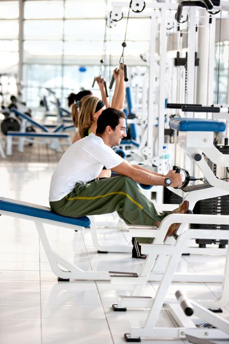 People at the gym exercising on machines