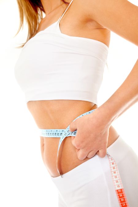 Woman measuring her waist isolated over white