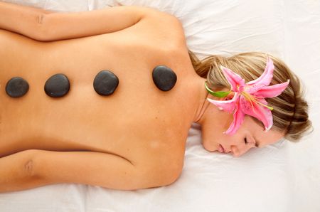 Beautiful Woman at a spa with stones on her back