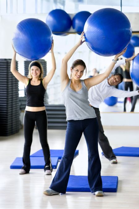 People in aerobics class at the gym with pilates ball
