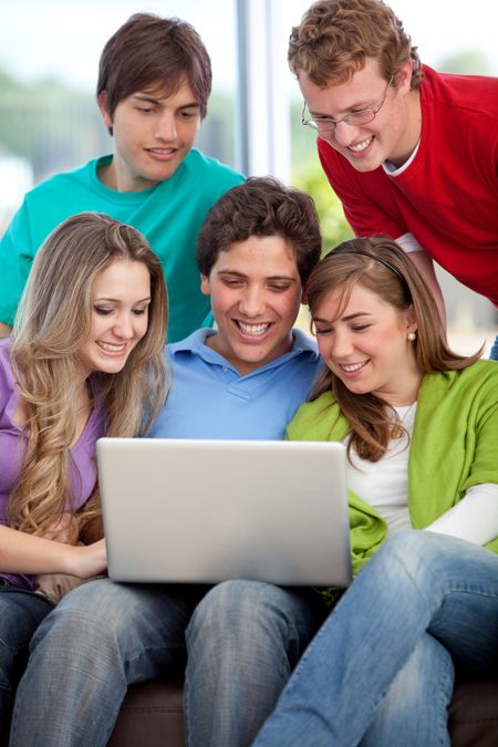 Happy group of friends with a laptop computer