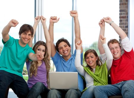 Excited group of friends with a laptop