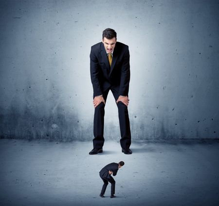 Angry huge business man lokking at small coworker guy concept on background