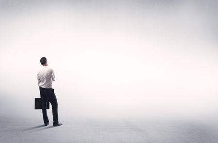 Corporate business male in modern suit standing in big blank empty grey space concept