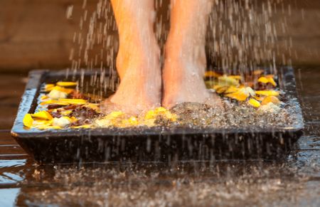 Woman moisting her feet with water and potpourri
