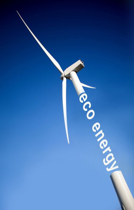 windmill over a blue sky generating eco energy