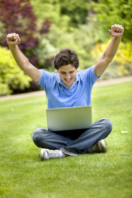 Happy man with a computer oudoors smiling
