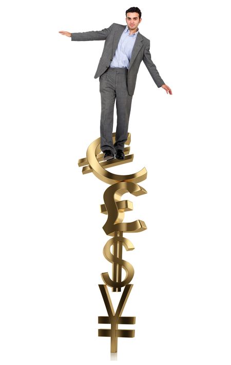 Businessman on a pile of currency symbols isolated