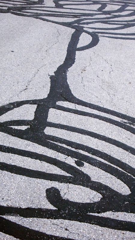 Street grunge: patterns of sealant on cracked asphalt