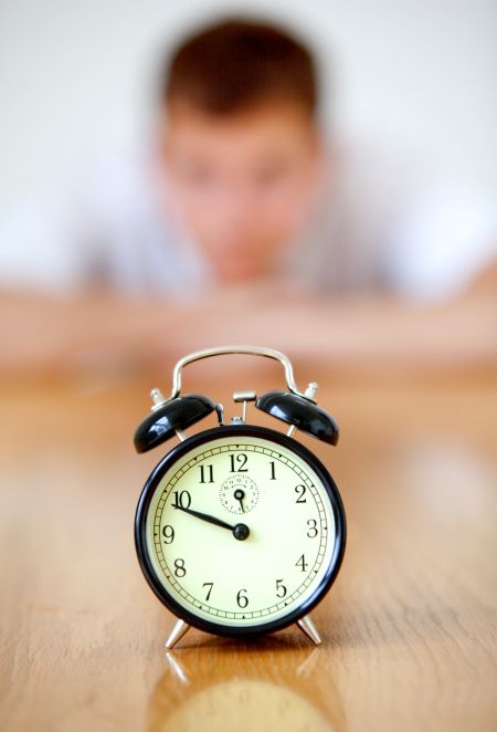 Man staring at an alarm clock isolated