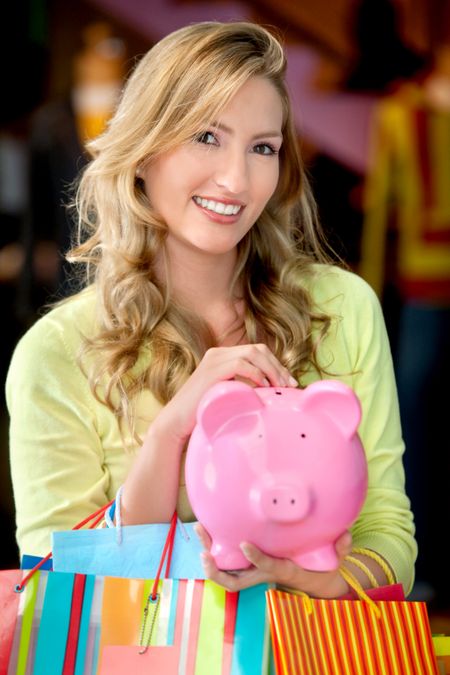 Woman with bags and a piggybank smiling
