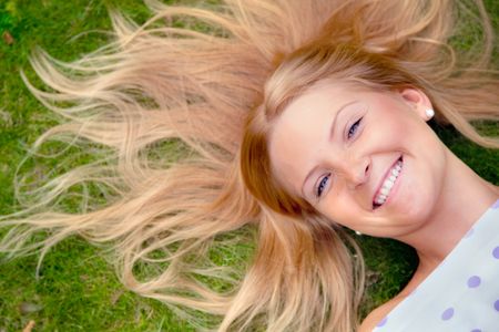 Beautiful woman portrait lying on the grass outdoors
