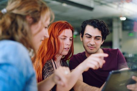 Unposed group of creative business people in an open concept office brainstorming their next project.