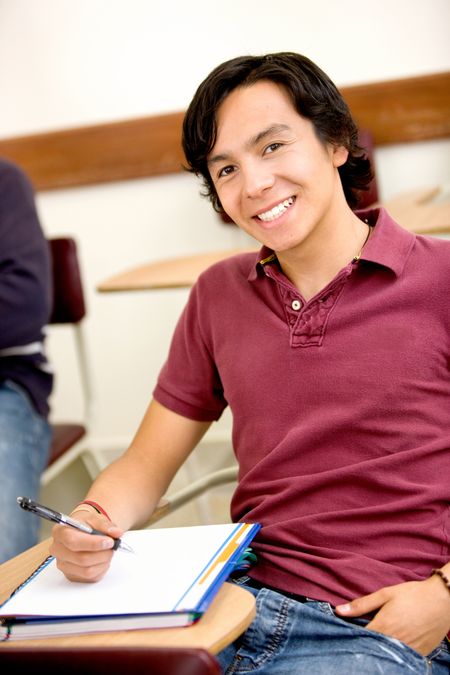 Handsome man studying in a classroom and smiling