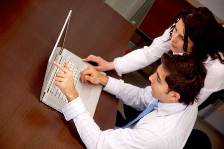 Business couple working with a laptop at an office