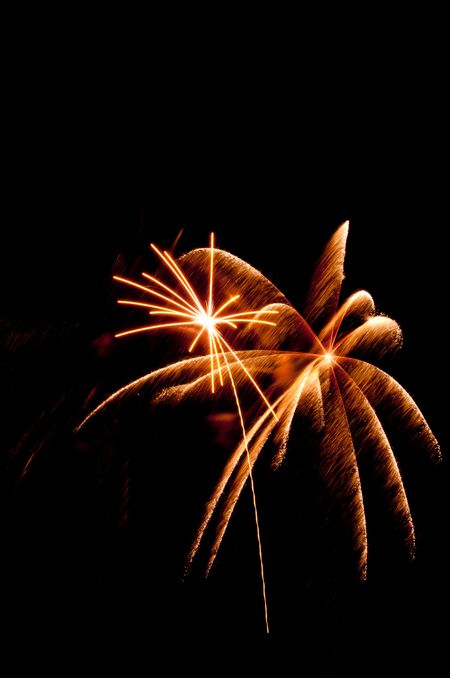 Motion-blurred burst of fireworks next took white-hot burst with rocket trail