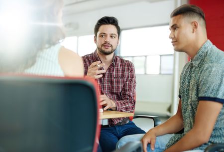 Unposed group of creative business people in an open concept office brainstorming their next project.